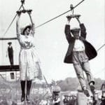 old fashioned picture of man and woman on a zip line