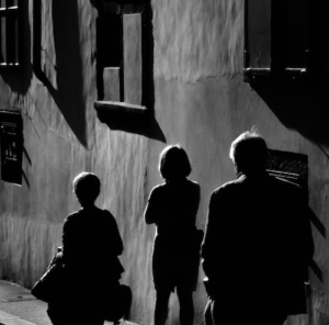 A family dealing with parental estrangement walking on a dark path alongside a building