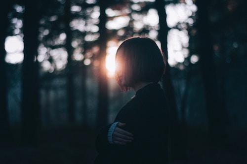 A woman walking through nature thinking about the signs of divorce