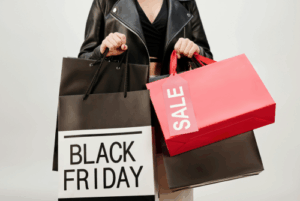 A woman holding multiple Black Friday and sale shopping bags, symbolizing emotional spending and the financial temptations many women face during and after divorce.