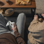 Couple sitting together playing video games, symbolizing routine and comfort in a long term relationship