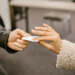 Two people exchanging a card, symbolizing a hall pass in marriage and shifting relationship boundaries