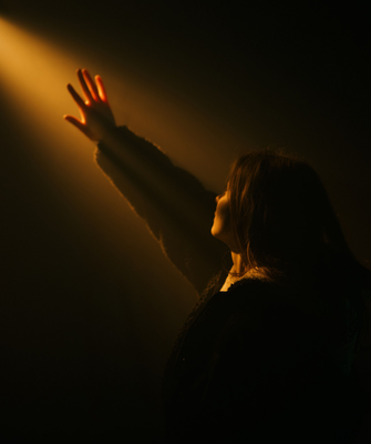 Woman reaching toward light, representing healing after divorce for women and the hope of a new beginning