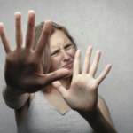 Woman holding up her hands in resistance, showing discomfort and emotional reaction to difficult news