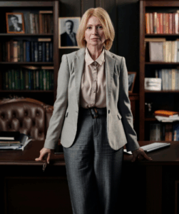 Professional female divorce attorney standing in her office with bookshelves behind her, conveying confidence and authority.