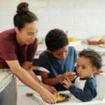 Mother feeding her children in a kitchen, representing stability and care in a parallel parenting environment