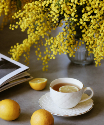 Cup of lemon tea beside fresh flowers, symbolizing comfort, healing, and new beginnings after divorce