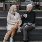 Two older women sitting together outdoors, representing a committed couple considering a civil union