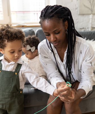 Mother helping her children with an activity at home, representing everyday coparenting coordination