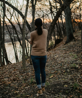 Woman walking alone through the woods, reflecting on whether she should get a divorce