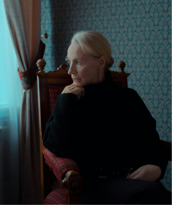 Woman sitting alone by a window, looking thoughtful, symbolizing emotional distance in a silent divorce
