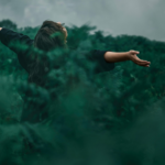 Woman standing in nature with her arms open, symbolizing freedom and reinvention after divorce