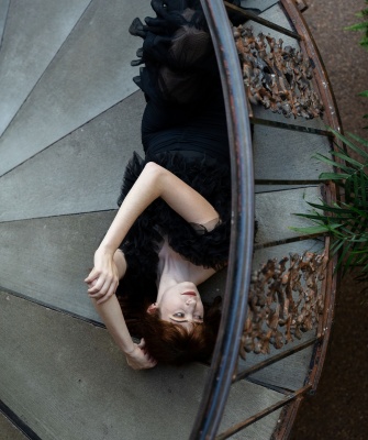 Woman lying on a staircase, appearing emotionally overwhelmed, representing the stress of an unhappy marriage