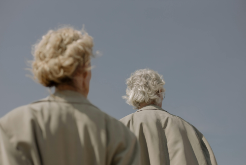pexels-cottonbro-5264859 Back of a gray-haired man and woman in raincoats.
