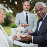 Older couple exchanging rings during an outdoor wedding ceremony, representing common law marriage and long term commitment.