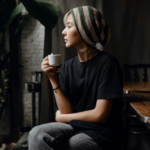 Woman sitting alone with a cup, reflecting on when to walk away after infidelity